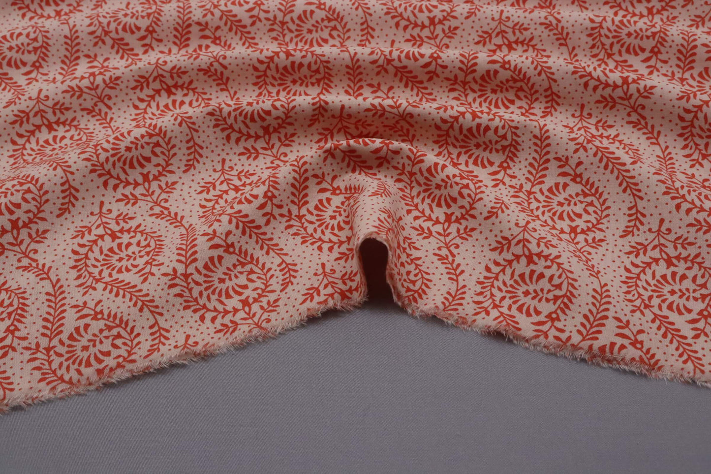 Tissu voile de coton imprimé floral rouge sur fond rosé | Volubile